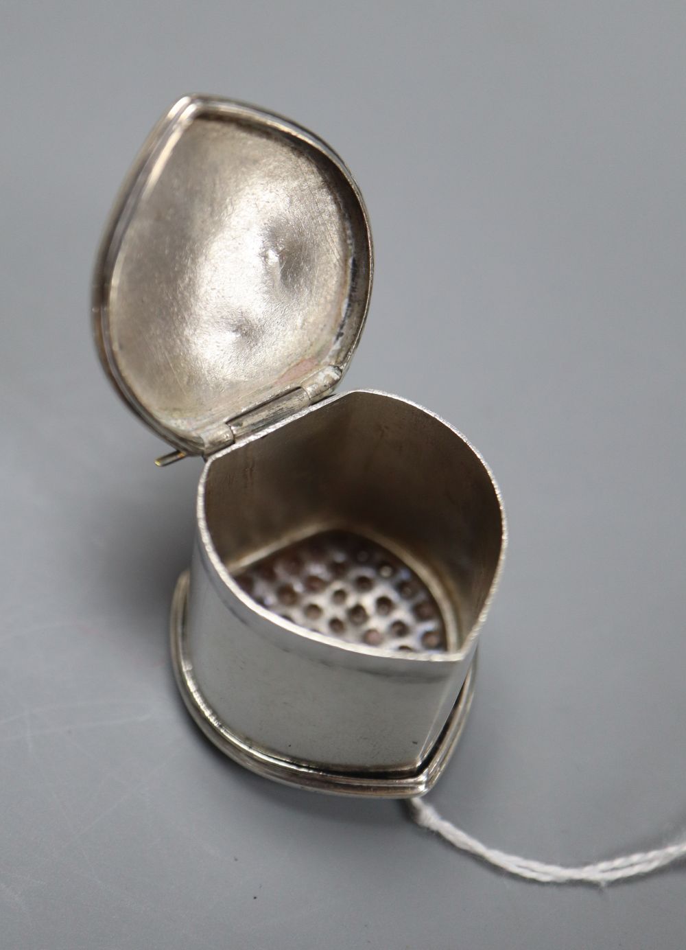 An 18ct century white metal nutmeg grater, with engraved initials, unmarked, 28mm.